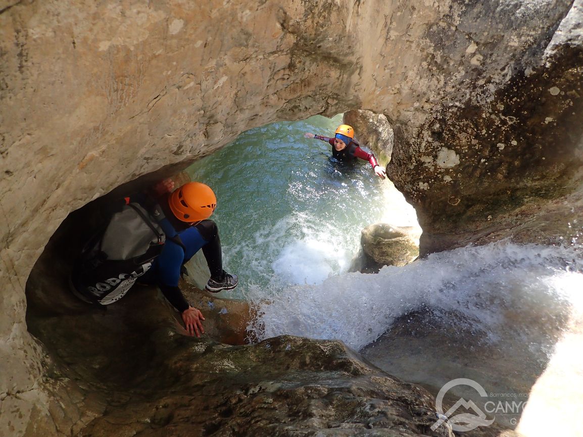 una persona junto a una cascada del barranco del Fornocal en las proximidades de Alquézar