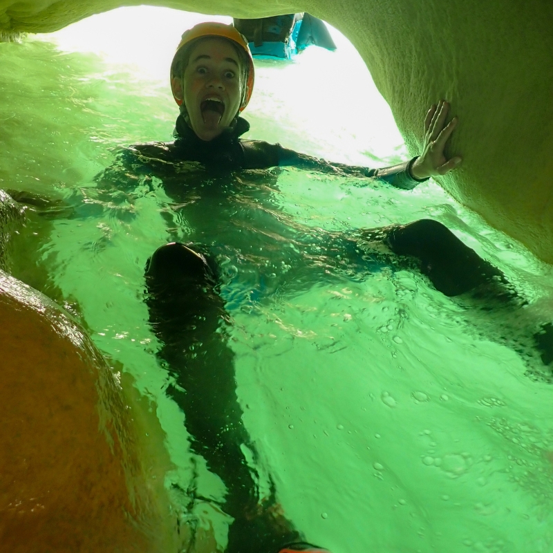 niño dentro de una cueva inundada de agua practicando barranquismo familiar Huesca
