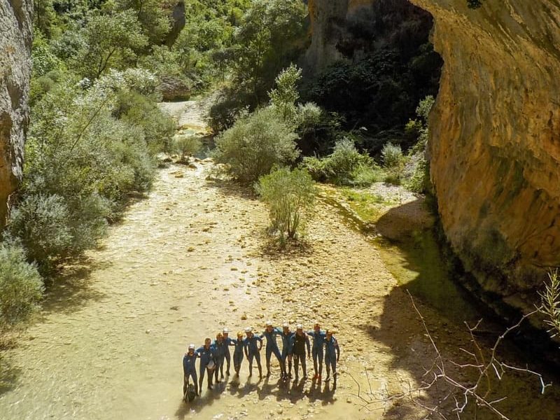 Grupo de personas mirando a cámara en el medio del cañón del río vero