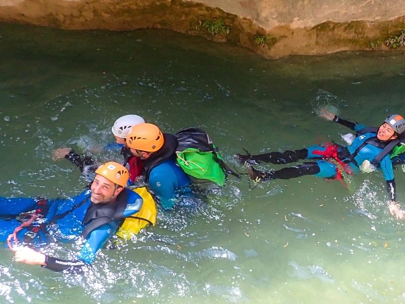 grupo practicando barranquismo en Rodellar flotando en el agua de un barranco