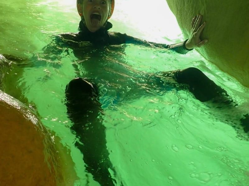 niño dentro de una cueva inundada de agua practicando barranquismo familiar Huesca