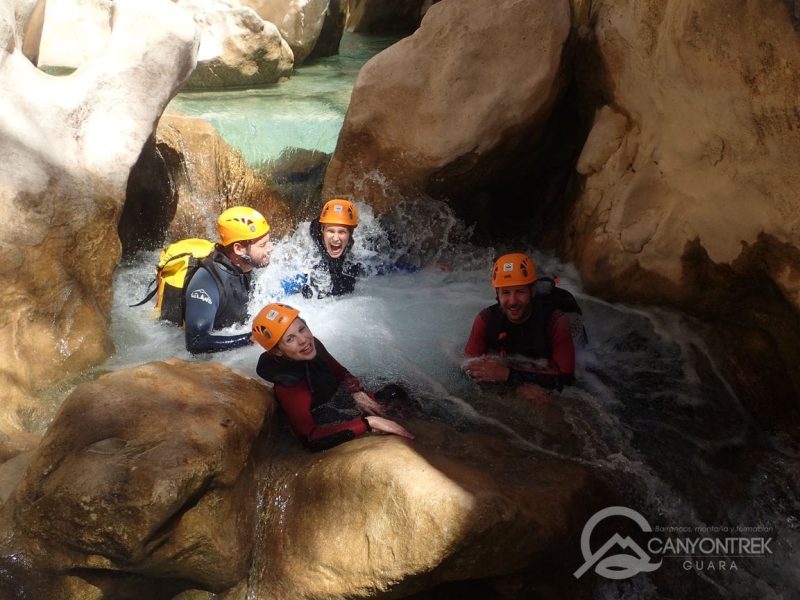 Cuatro personas en la poza de un barranco durante la actividad de barranquismo en Sierra de Guara