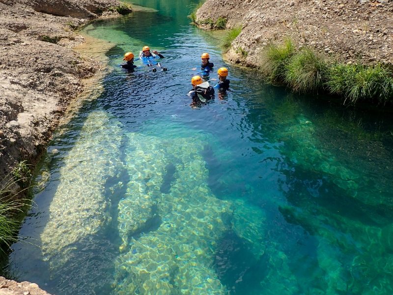 cinco personas flotando en una piscina natural del barranco la peonera