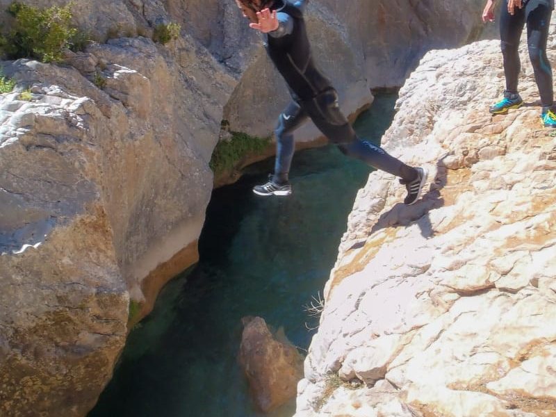 persona saltando sobre las aguas del barranco la peonera con casco de seguridad
